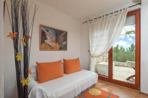 a bedroom with a bed with orange pillows and a window at Holiday house with a swimming pool Sveta Nedilja, Hvar - 22136 in Jelsa