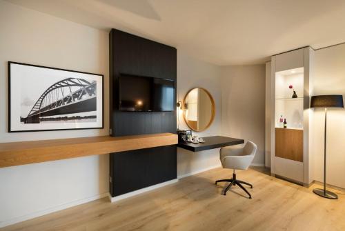 a room with a desk and a tv and a chair at Crowne Plaza Düsseldorf - Neuss by IHG in Neuss
