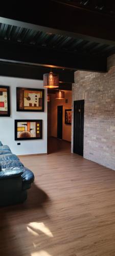 HOTEL MAQUIAVELO SOLO ADULTOS في بوبلا: غرفة معيشة مع أريكة وجدار من الطوب