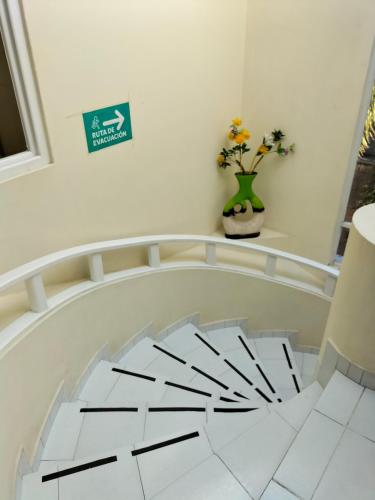 a room with a white floor and a vase with flowers at Hotel Teui Formarte Grupos in Celaya