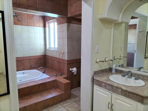 ein Badezimmer mit zwei Waschbecken und einer Badewanne in der Unterkunft Hotel Teui Formarte Grupos in Celaya