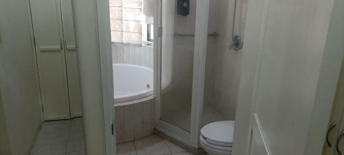 a bathroom with a shower and a toilet and a sink at Hotel Teui Formarte Grupos in Celaya