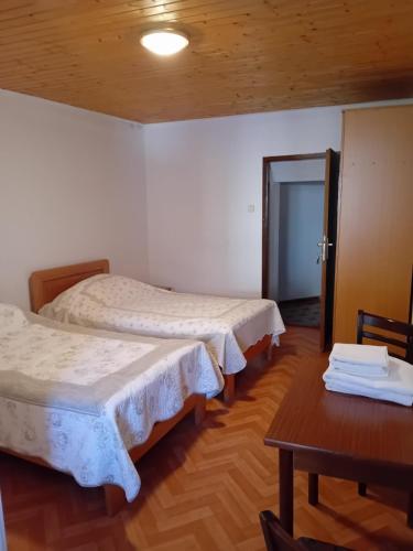 - 2 lits dans une chambre avec une table et une porte dans l'établissement Rooms with a parking space Jelovice, Central Istria - Sredisnja Istra - 22787, à Lanišće