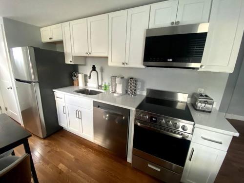 a kitchen with white cabinets and a stainless steel appliances at It’s Showtime-Book Lally’s House! Steps to Common! in Salem