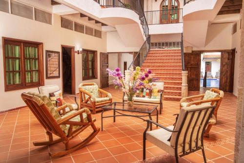 a lobby with chairs and a table and stairs at Hotel Casa Moreno La vega C in La Vega