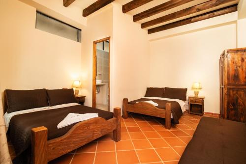 a bedroom with two beds and a chair in it at Hotel Casa Moreno La vega C in La Vega