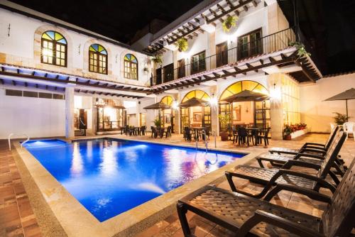 a pool in a building with chairs and tables at Hotel Casa Moreno La vega C in La Vega