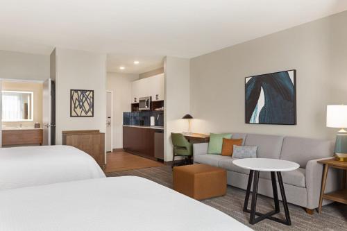 ポート・エルジンにあるStaybridge Suites Port Elgin, an IHG Hotelのベッド2台とソファが備わるホテルルームです。