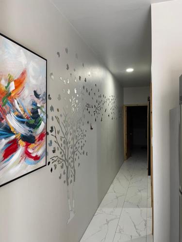 a wall with a painting of a tree with birds at Home Away From Home in Kingston