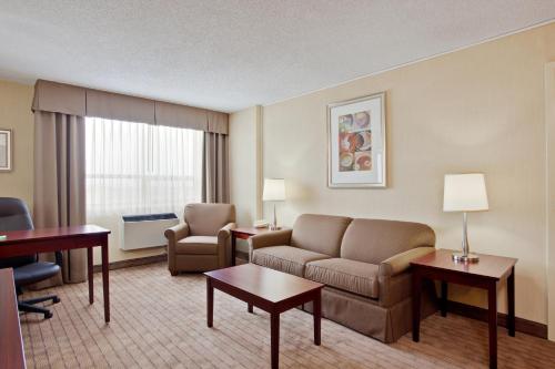 - un salon avec un canapé et une chaise dans l'établissement Holiday Inn & Suites Winnipeg Downtown, an IHG Hotel, à Winnipeg