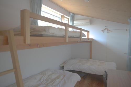 Guesthouse Muga في هيكونا: سريرين بطابقين في غرفة مع نافذة