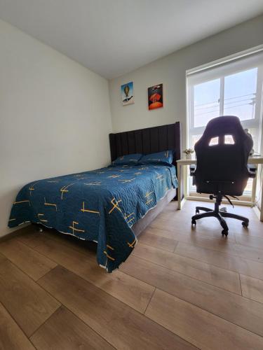 1 dormitorio con cama, escritorio y silla en Hab. privada compartida en departamento cerca del aeropuerto, en La Libertad