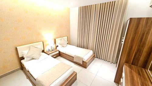 a hotel room with two beds and a window at Rahhal AlBahr Serviced Apartments in Jeddah