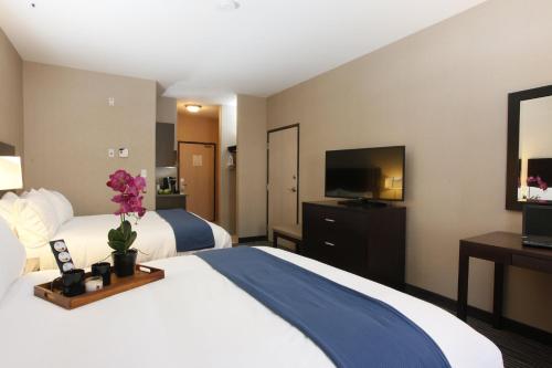 a hotel room with two beds and a flat screen tv at Holiday Inn Express Fort St John, an IHG Hotel in Fort Saint John