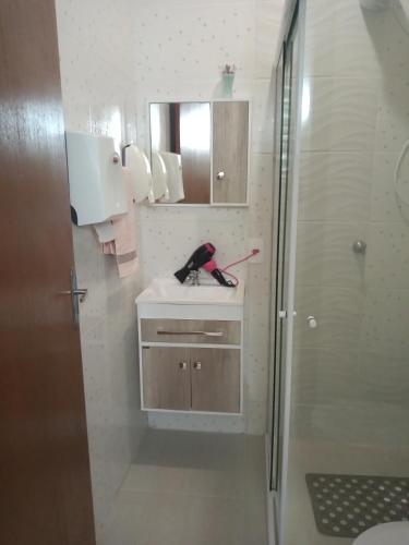 La salle de bains est pourvue d'un lavabo et d'une douche. dans l'établissement Apartamento Studio Central, à Navegantes