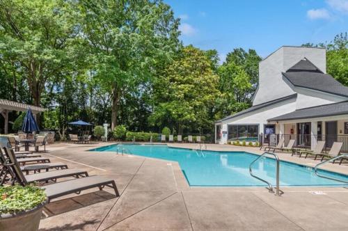 a swimming pool with chaises and chairs next to a building at Luxury & Convenience in South End Charlotte in Charlotte