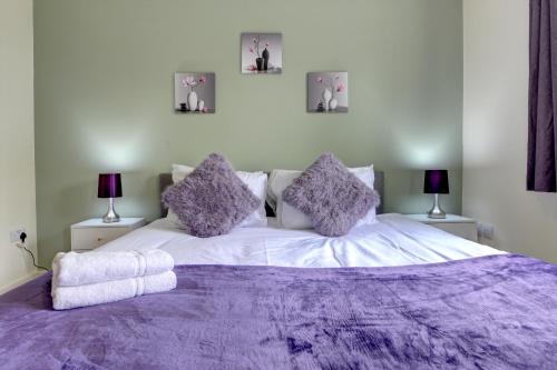 a bedroom with a large purple bed with two lamps at Modern Comfort, 2BR, Ensuite, Parking in Rugby
