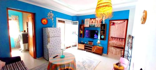 uma sala de estar com paredes azuis e um frigorífico em Chez trina house em Bizerte