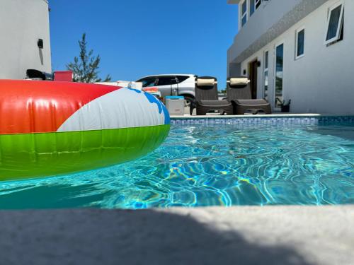 a swimming pool with an inflatable at Ocean Pearl - A brand new one bedroom with pool, walkable distance to sunset beach in Long Bay Hills