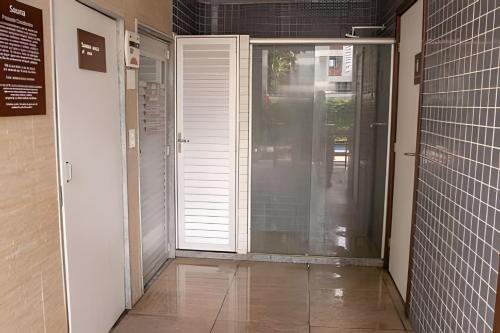 a hallway with a door and a tile floor at Hosts BR - Flat Beach Class Boa Viagem (sem taxas) in Recife