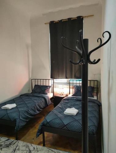 two twin beds in a room with a window at Waterfall Hostel in Sarajevo