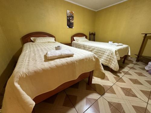 a bedroom with two beds with towels on them at Dream House B&B in Huaraz