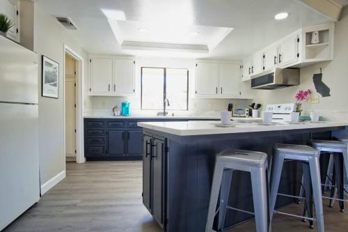 a kitchen with blue cabinets and a large island with bar stools at Oakridge Ranch ※ Sequoia, Kern River & Lake Escape in Lake Isabella