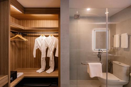 a bathroom with a toilet and a glass shower at Holiday Inn Sepang - Airport in Sepang