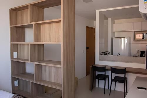 eine Küche mit Holzregalen und 2 Stühlen in einem Zimmer in der Unterkunft Hosts BR - Estúdio em Boa Viagem(s/taxas) in Recife