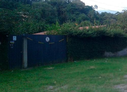a blue fence in a yard next to a field at Chalé Sol de Primavera in Arujá