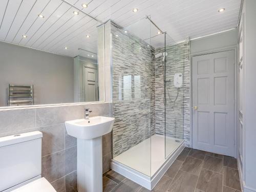 a bathroom with a shower and a sink and a mirror at Stenson Hill Farm in Melbourne