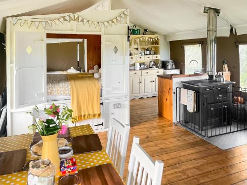 a kitchen and living room with a table and a stove at Buttercup - Uk45986 in Paul