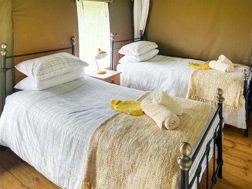 two beds with white sheets and towels on them at Buttercup - Uk45986 in Paul