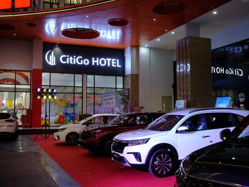 un grupo de coches estacionados frente a un hotel en CitiGo HOTEL - 越南平阳新渊欢阁酒店 