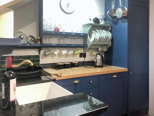 cocina con armarios azules y encimera en Hen Joppa, en Newlyn