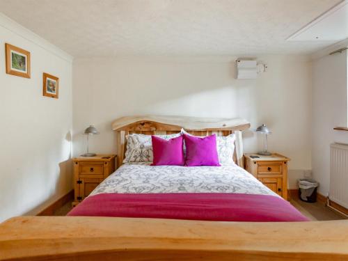 a bedroom with a large bed with pink pillows at The Nook in Yorkley