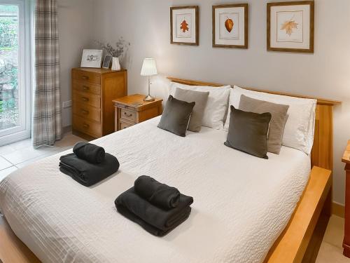 a bedroom with a large bed with two pillows on it at Old Kielder Castle Cottage in Kielder