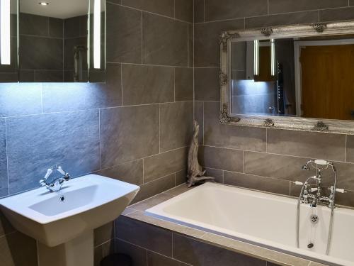 a bathroom with a sink and a bath tub at Old Kielder Castle Cottage in Kielder