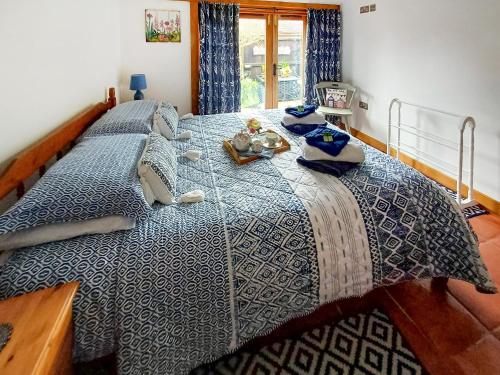 a bedroom with a large bed with a blue comforter at Meadow Barn in Wool