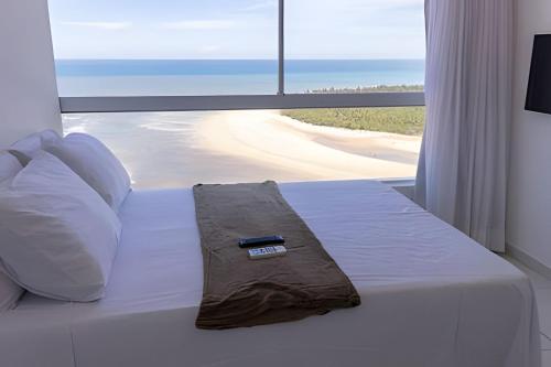 a bedroom with a bed with a remote control on it at Hosts BR - Flats Frente Mar c/ Cozinha in Recife