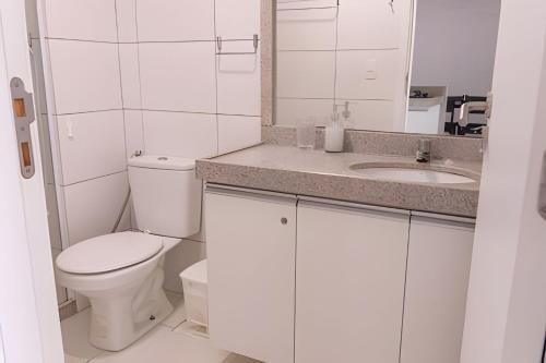 a white bathroom with a toilet and a sink at Hosts BR - Flats Frente Mar c/ Cozinha in Recife