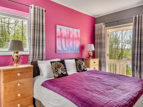 a purple bedroom with a bed and two windows at Dunburgh Wood in Beccles