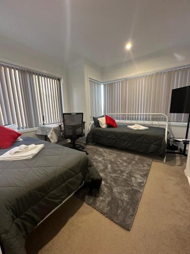 a bedroom with two beds and a flat screen tv at Private Room in Townhouse in Wollongong