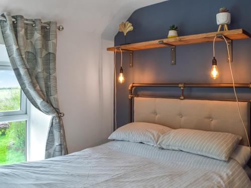 a bedroom with a bed with lights on the headboard at Frondeg in Blaenporth