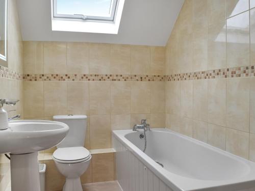 a bathroom with a toilet and a bath tub and a sink at Frondeg in Blaenporth