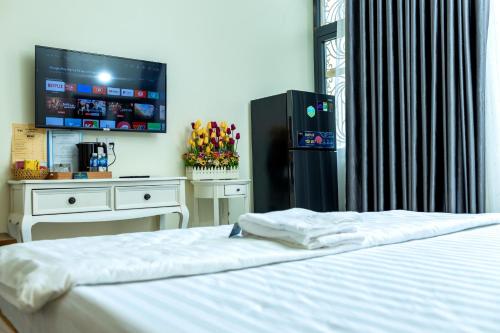 a bedroom with a bed and a flat screen tv at Tân Hiệp Hotel in Bùi Tiếng