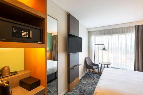 a hotel room with a bed and a desk at Holiday Inn Express & Suites Queenstown by IHG in Queenstown