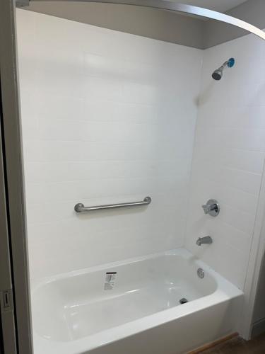 ein weißes Bad mit einer Badewanne und einem Handtuchhalter in der Unterkunft Rosewood Inn in Union City