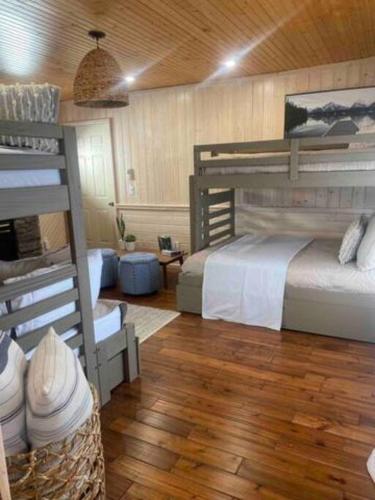 a bedroom with two bunk beds and a wooden floor at The Driftwood - Hot tub with Lake views in Leamington