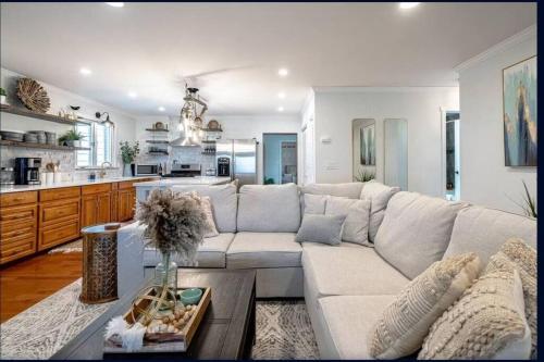 a living room with a white couch and a kitchen at The Driftwood - Hot tub with Lake views in Leamington